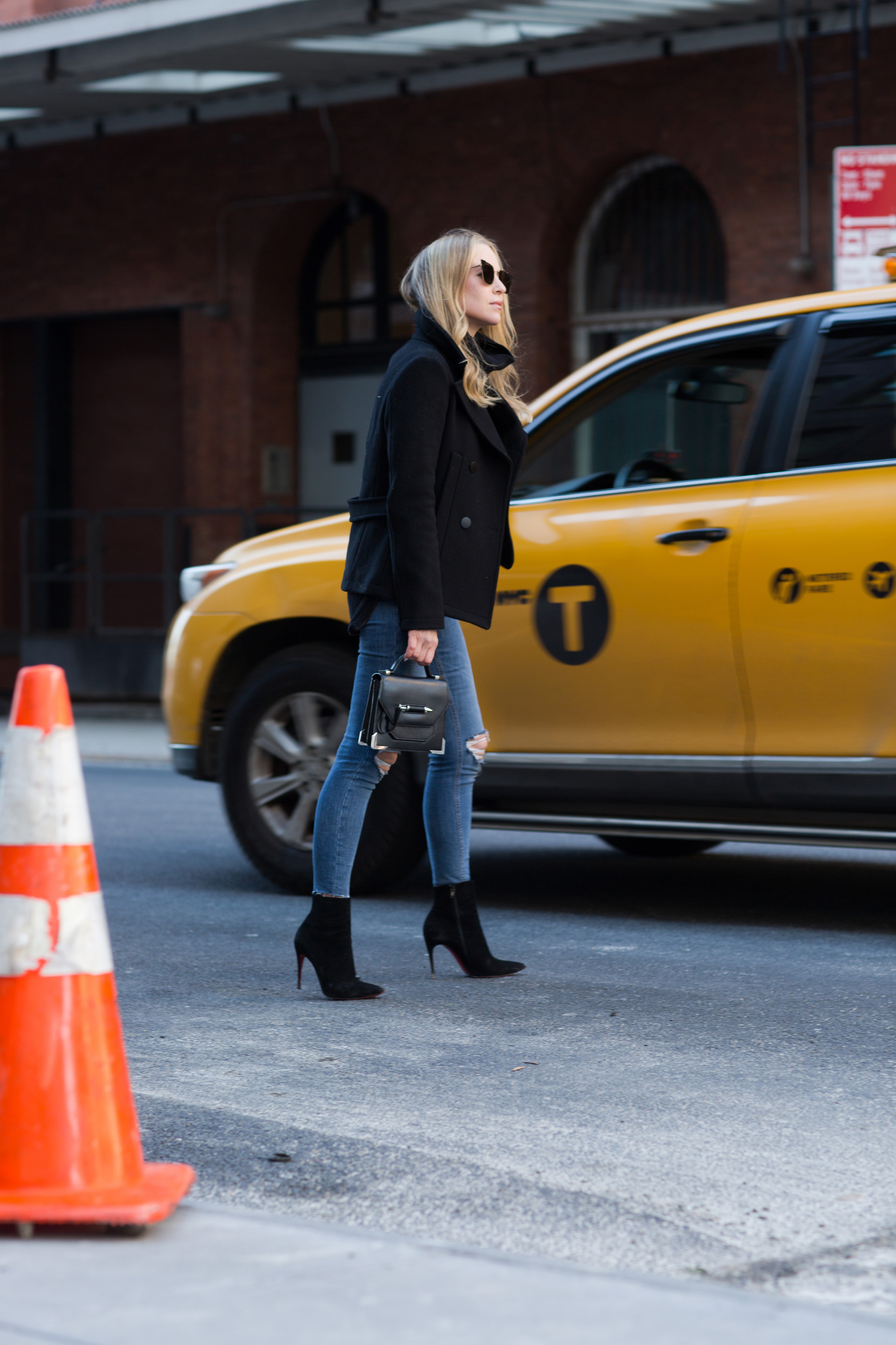 winter work day outfits inspiration - Helena Glazer of Brooklyn Blonde wearing Slate & Stone black Peacoat with black turtleneck sweater, distressed denim, Louboutin boots, Fendi Sunglasses, and Mackage handbag