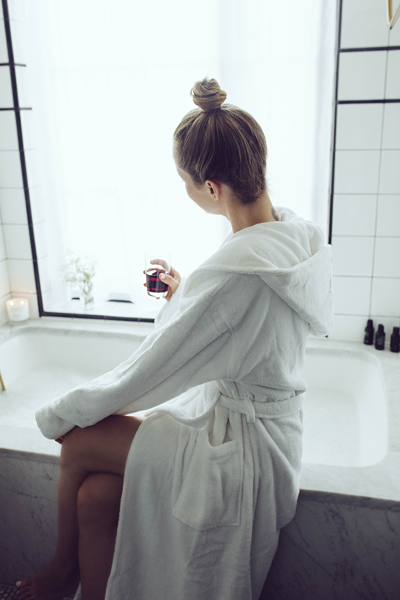 Brooklyn Blonde Blogger Helena Glazer shares her Lash Lift Reviews NYC - in photo: woman sitting on her bathtub