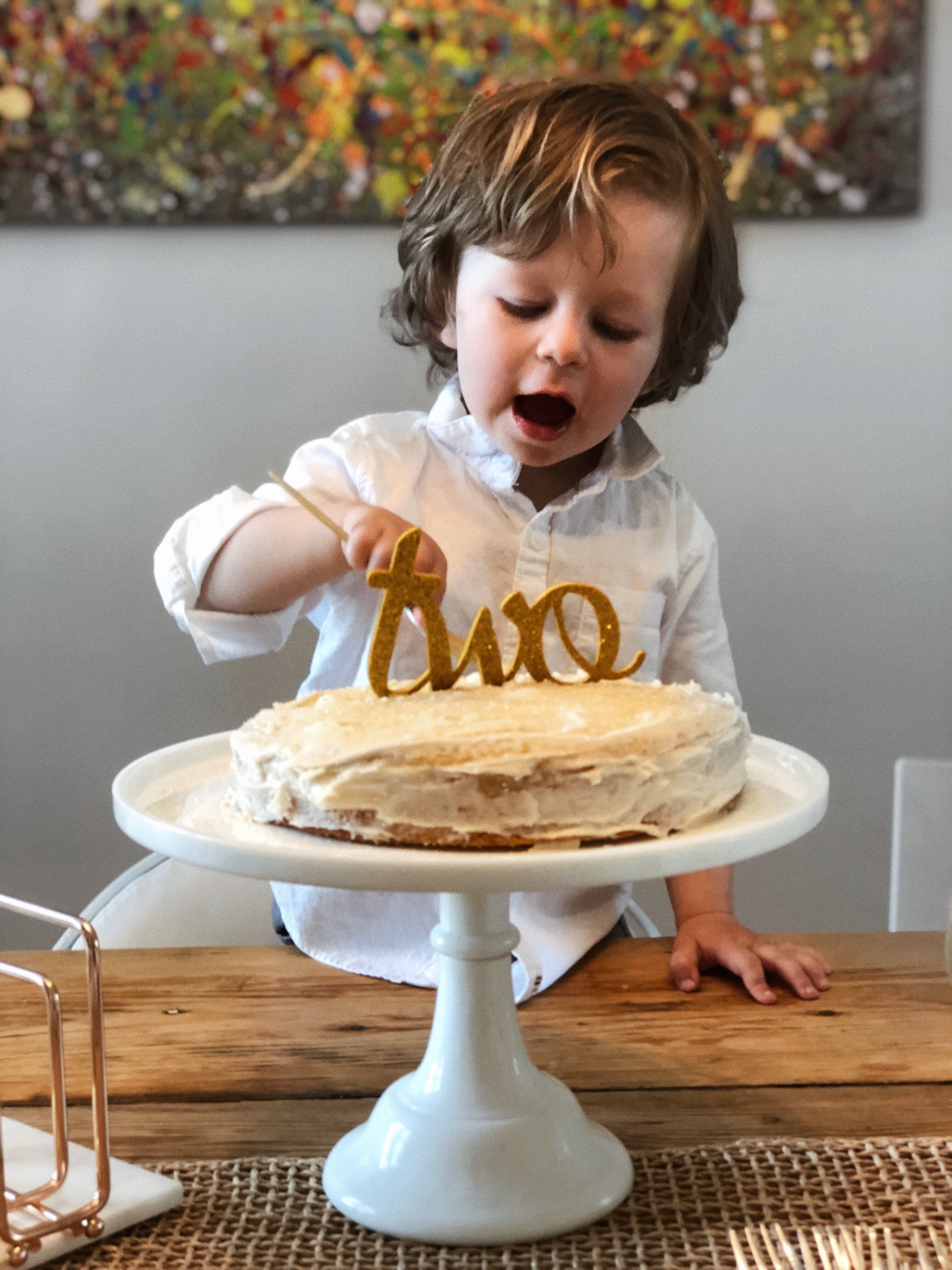 nate celebrating his second birthday with a cake