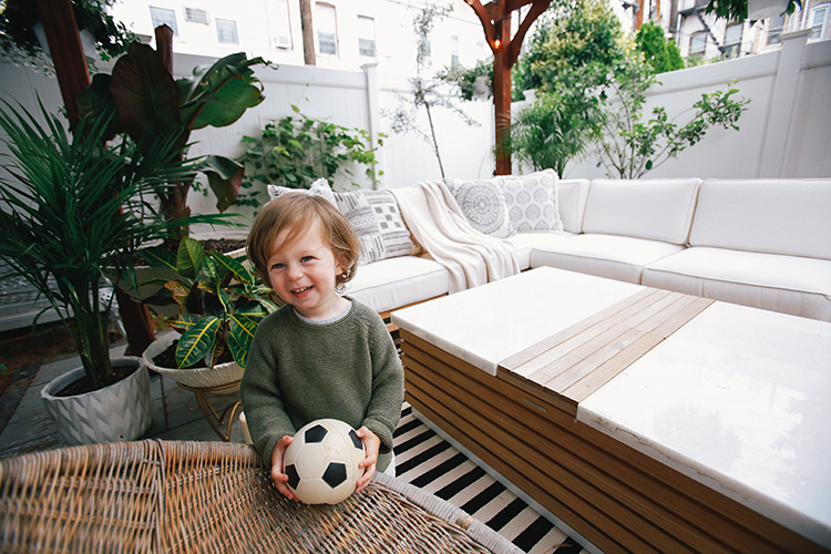 Toddler in their newly renovated Urban Oasis Backyard Backyard