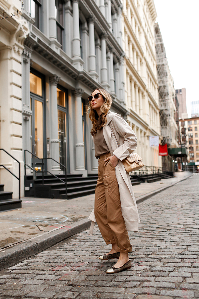 woman wearing trench coat for everyone, brown baggy pants, and a shirt