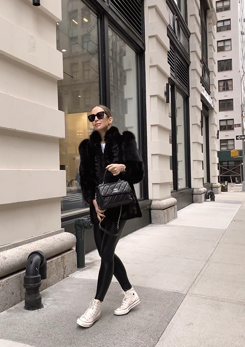 woman wearing leggings, fur jacket and holding Chanel Trendy CC Bag