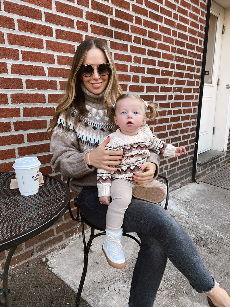 woman with a little girl on her lamp and they're wearing sweaters