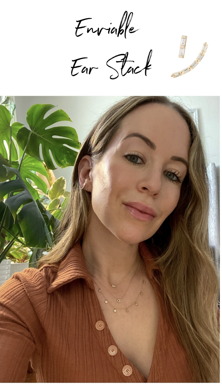 woman taking a selfie and wearing earrings and stack necklaces