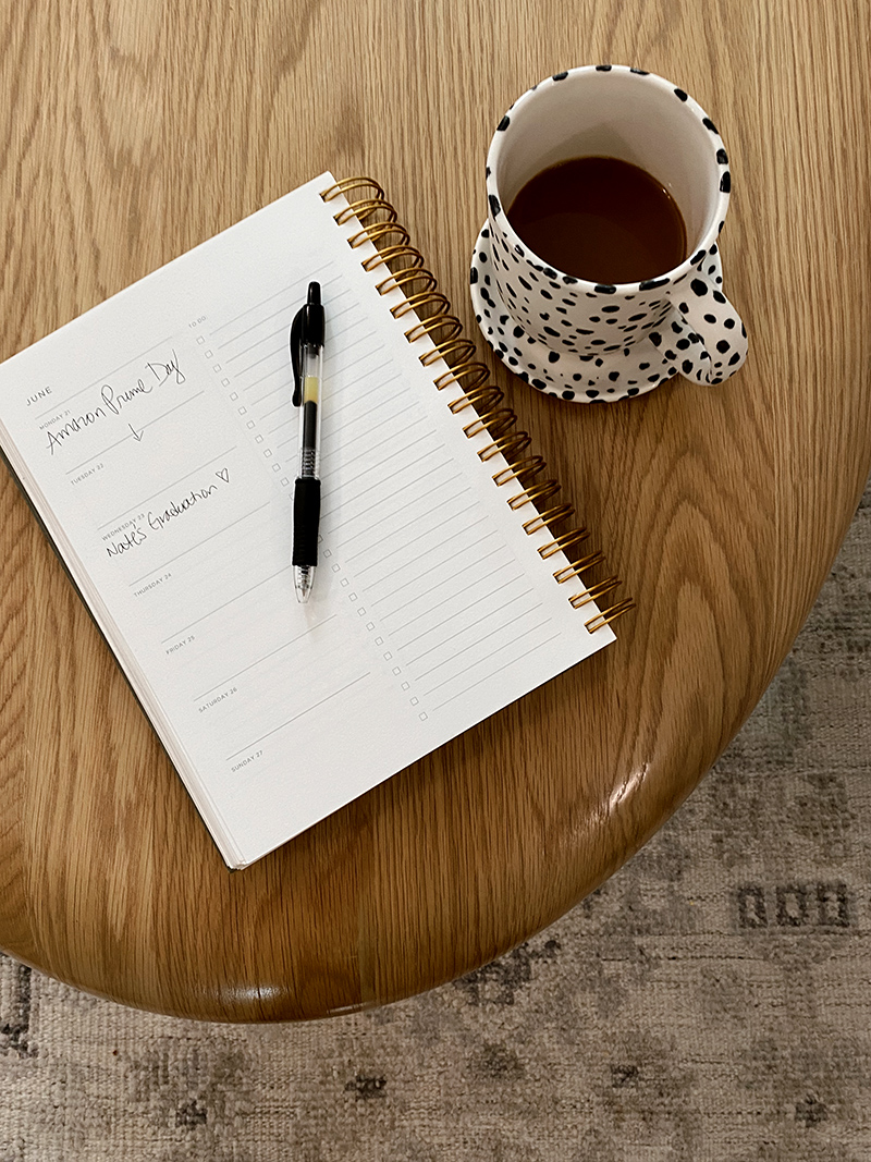 open notebook written on it s Amazon Prime Sale and a coffee mug on a table for 