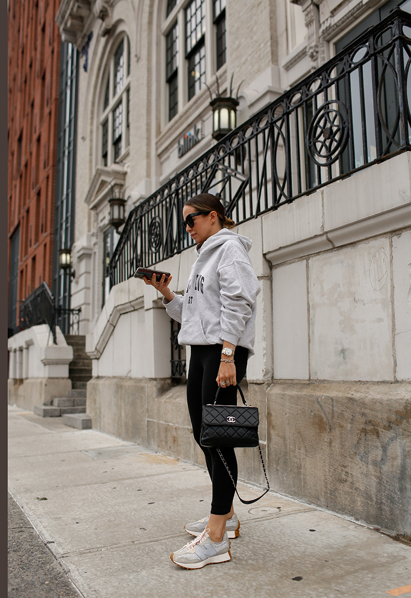 woman on the street using her phone with school drop off outfit