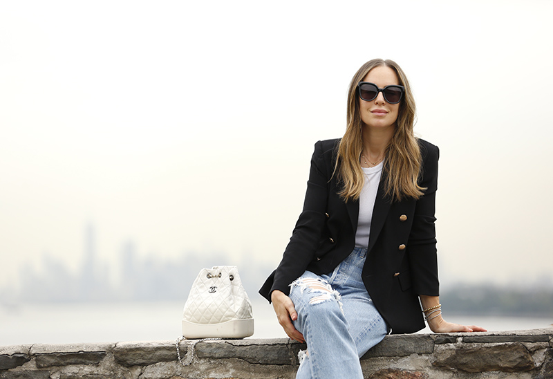 woman wearing white shirt, black blazer, and jeans