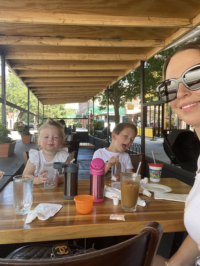 woman and her two kids eating in an outdoor dining sharing Tips on Solo Parenting