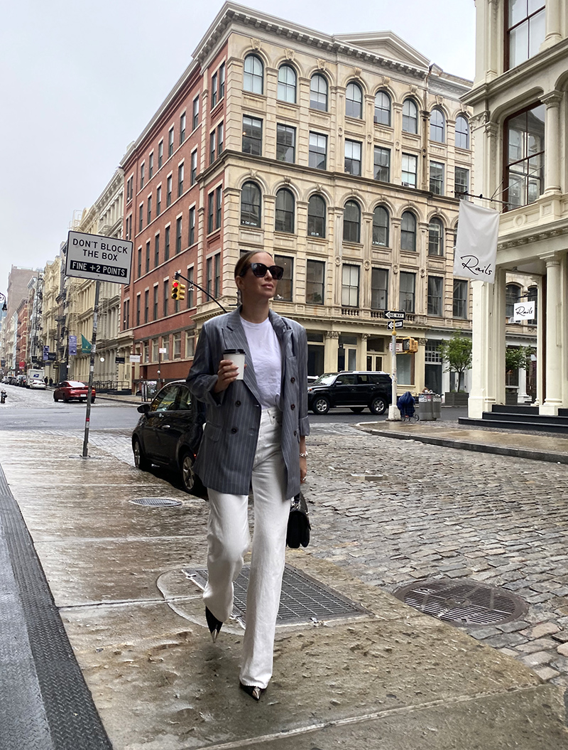 woman in Pinstripes and Denim Trousers and holding her coffee 