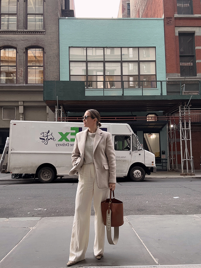 woman showing one of her Seven Recent Outfits where she wears a wide leg pants, Gucci shoes, a jacket, and a holding a brown bag