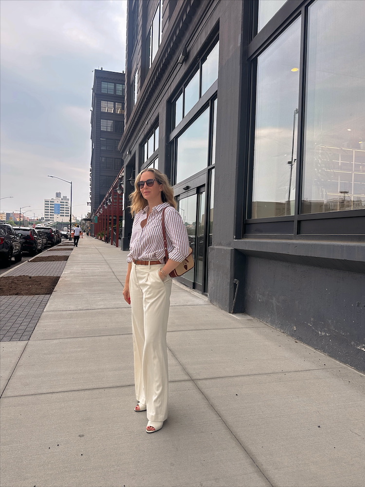 woman in summer dressing and wearing Sézane Shirt and Sézane Milo Bag