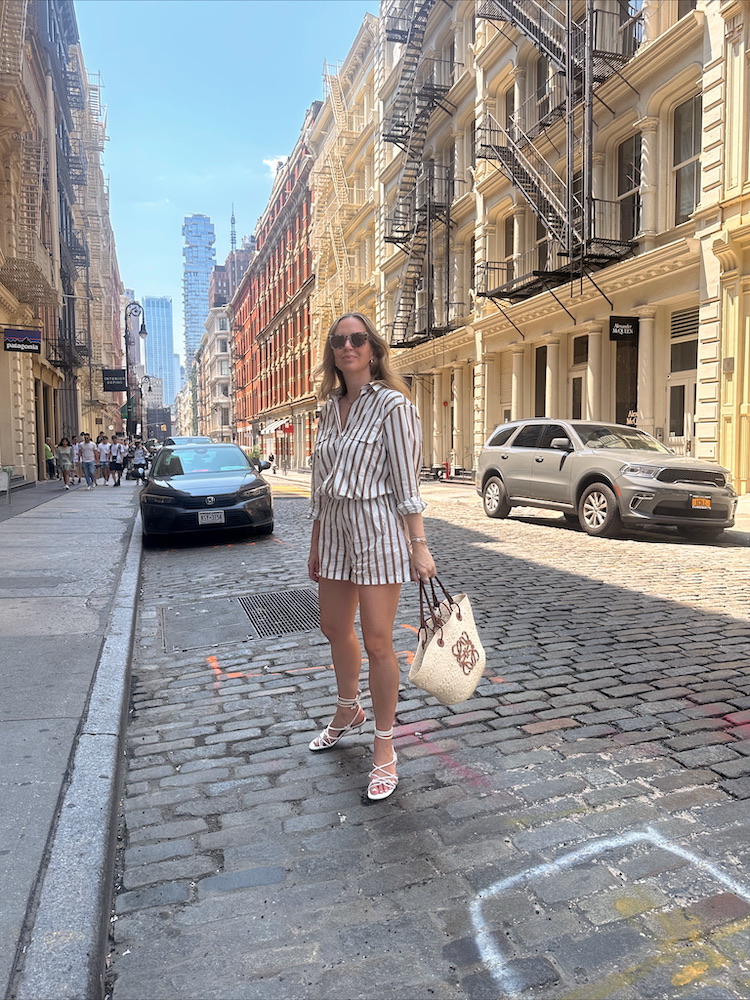 Helena Glazer wearing MIKOH Striped Shirt & Matching Shorts, GANNI Sandals, AIRE Sunglasses, Loewe Woven Raffia Tote for summer dressing